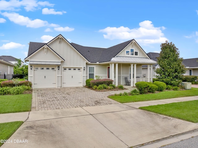 view of front facade with a front lawn, a garage, and covered porch