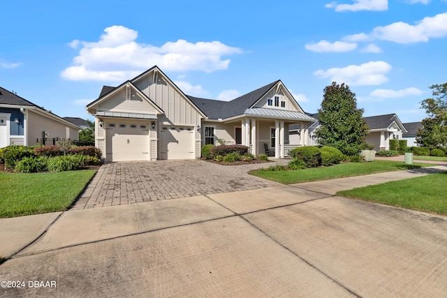 craftsman-style home featuring a front yard, a garage, and covered porch