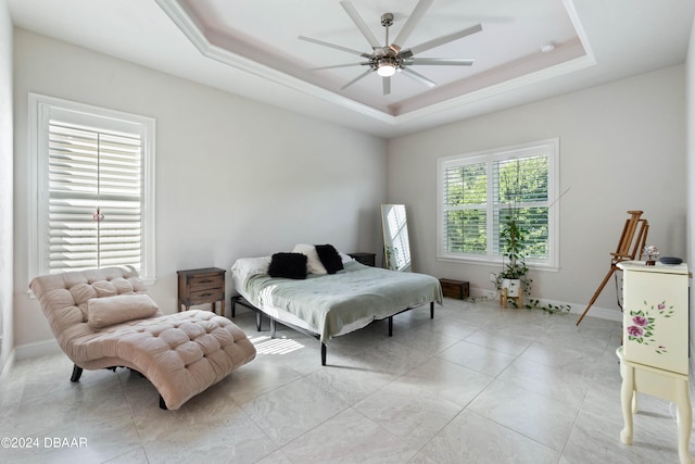 bedroom with ceiling fan and a tray ceiling