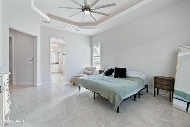 bedroom with a raised ceiling, ceiling fan, and ensuite bath