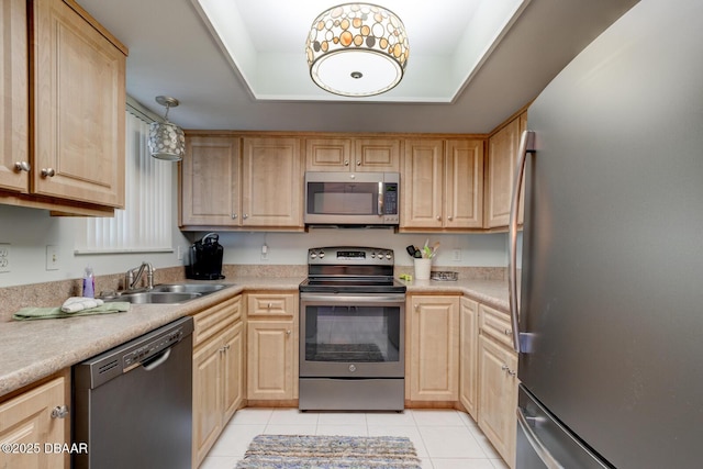 kitchen featuring light brown cabinetry, appliances with stainless steel finishes, and a sink