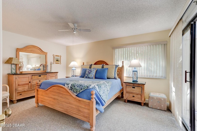 carpeted bedroom featuring a ceiling fan and a textured ceiling