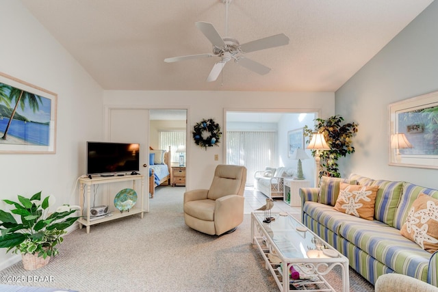 living room with lofted ceiling, carpet floors, and a ceiling fan