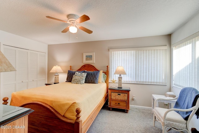 bedroom with carpet floors, a closet, ceiling fan, a textured ceiling, and baseboards