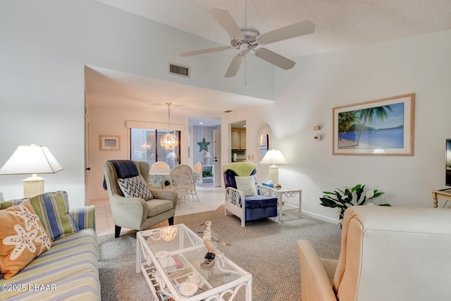 living room featuring light carpet, baseboards, visible vents, a textured ceiling, and ceiling fan with notable chandelier