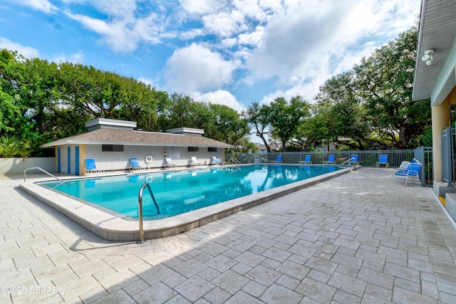 community pool with a patio and fence