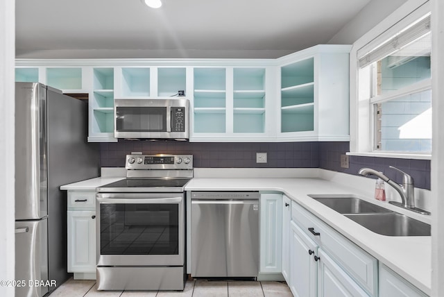 kitchen featuring sink, white cabinetry, stainless steel appliances, and light tile patterned floors