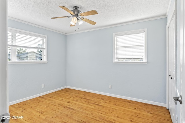 empty room featuring ceiling fan, light hardwood / wood-style floors, a textured ceiling, and ornamental molding