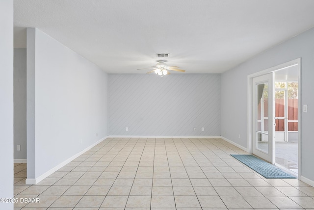 tiled spare room featuring ceiling fan