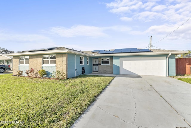 single story home with solar panels, a garage, and a front yard