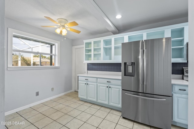 kitchen featuring decorative backsplash, stainless steel fridge, ceiling fan, beamed ceiling, and light tile patterned flooring