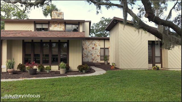 829 N Beach St, Ormond Beach, FL 32174 - back of property featuring a yard, a chimney, and stone siding