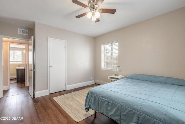 bedroom with multiple windows, wood finished floors, visible vents, and baseboards