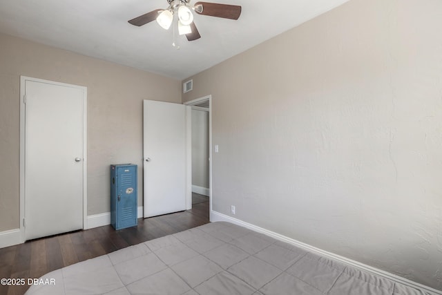 unfurnished bedroom with ceiling fan, wood finished floors, visible vents, and baseboards