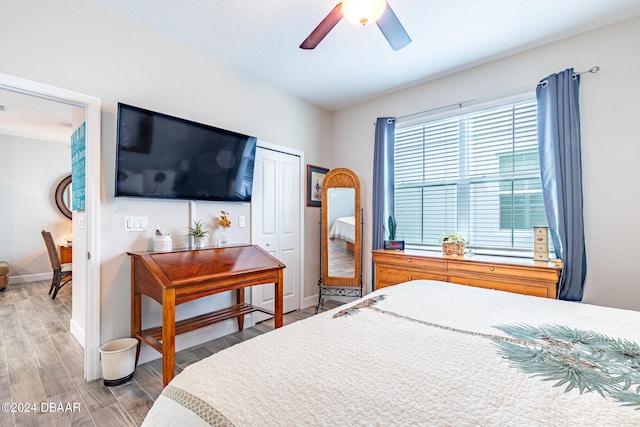 bedroom featuring hardwood / wood-style flooring, ceiling fan, and a closet