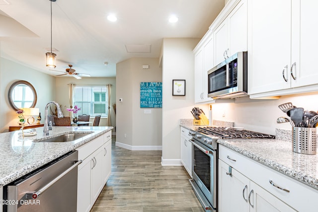 kitchen with white cabinets, light hardwood / wood-style floors, stainless steel appliances, and sink