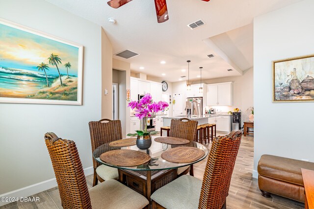 dining area with ceiling fan and light hardwood / wood-style flooring