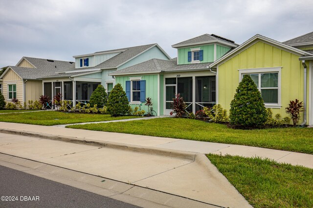 view of front facade featuring a front yard and a sunroom