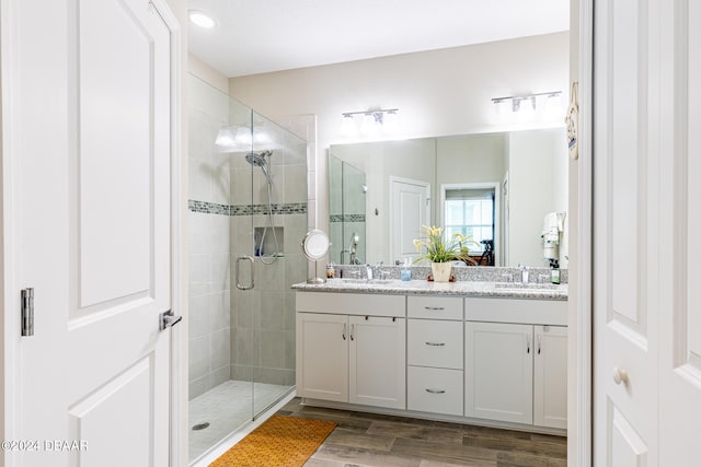 bathroom featuring vanity, wood-type flooring, and a shower with shower door