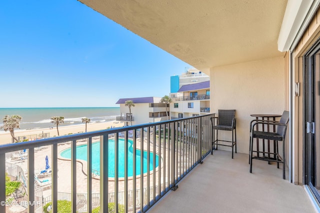 balcony with a water view and a beach view