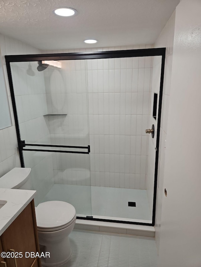 full bath featuring vanity, toilet, a stall shower, and tile patterned flooring