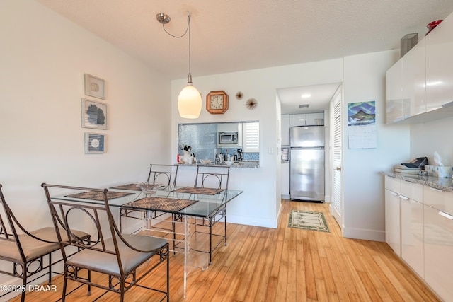 dining room with baseboards and light wood-style floors