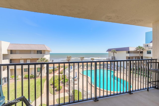 balcony featuring a view of the beach and a water view