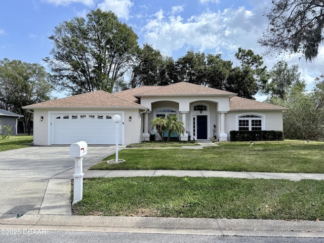 view of front facade featuring a garage, a front lawn, and stucco siding