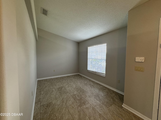 unfurnished room with a textured ceiling