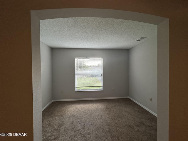 carpeted spare room with a textured ceiling