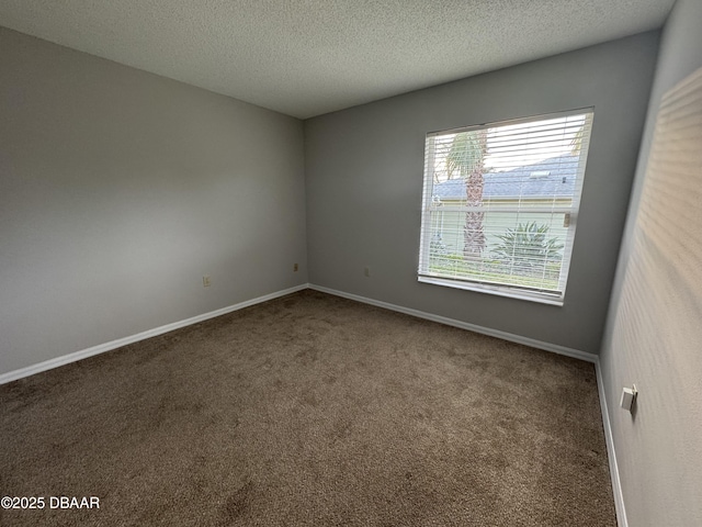 carpeted spare room with a textured ceiling