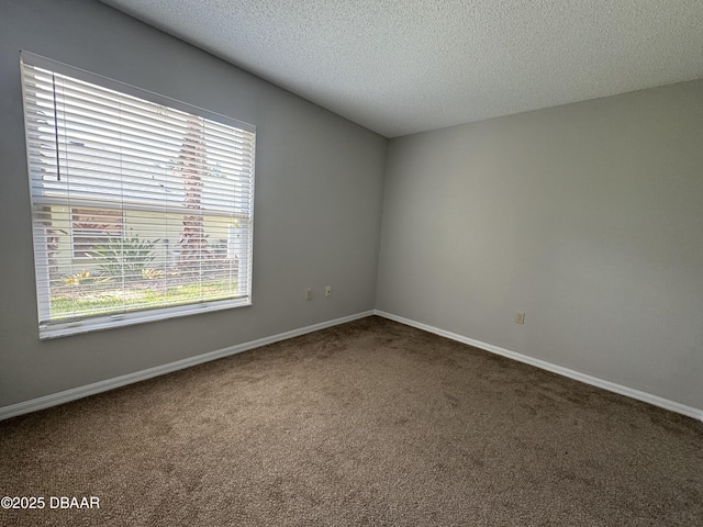 carpeted empty room with a textured ceiling