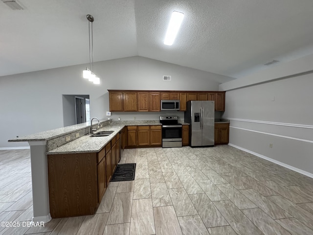 kitchen with sink, kitchen peninsula, pendant lighting, stainless steel appliances, and light stone countertops