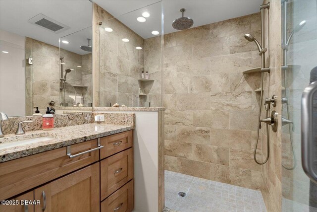 bathroom with vanity and a tile shower