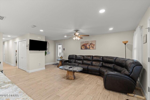 living room featuring ceiling fan and light hardwood / wood-style floors