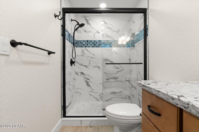 bathroom with toilet, vanity, and an enclosed shower