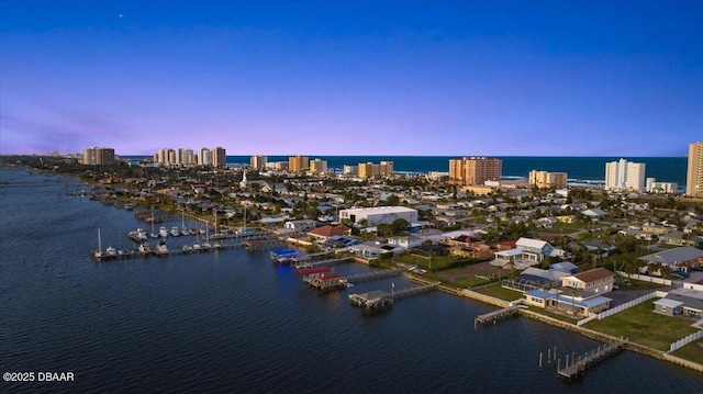 aerial view at dusk featuring a water view