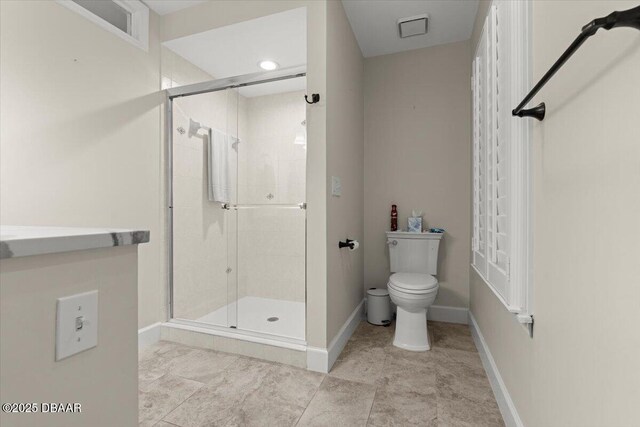 bathroom with toilet and a shower with door