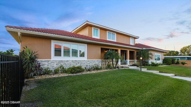 view of front of property featuring covered porch and a yard