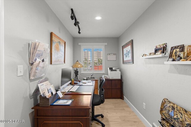 office space featuring light hardwood / wood-style floors and rail lighting