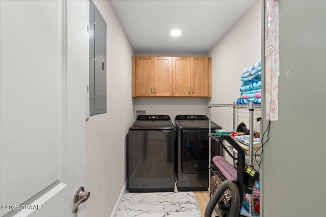 washroom featuring cabinets, electric panel, and washing machine and clothes dryer