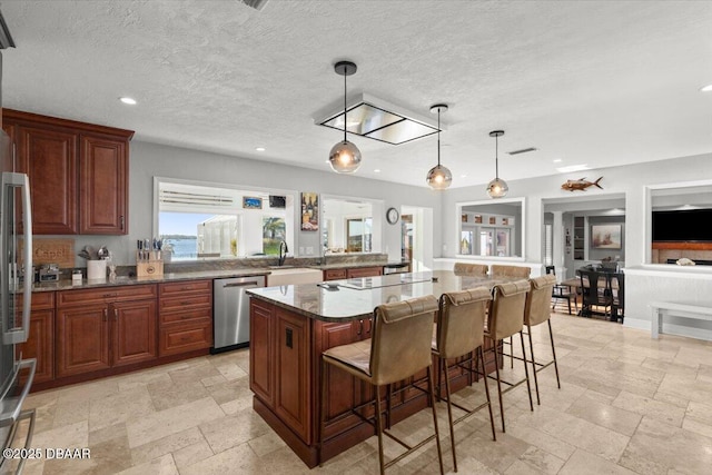 kitchen featuring a breakfast bar, dishwasher, pendant lighting, and a kitchen island