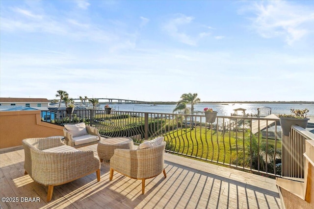 deck with a water view and a lawn