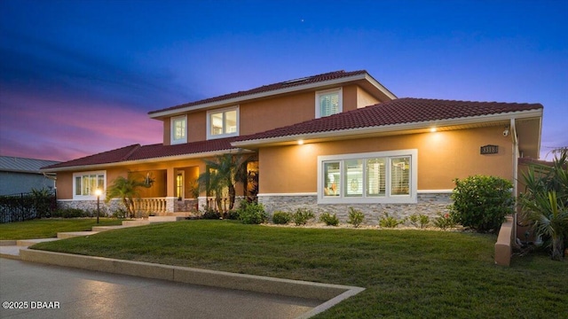 mediterranean / spanish-style home featuring a lawn and a porch