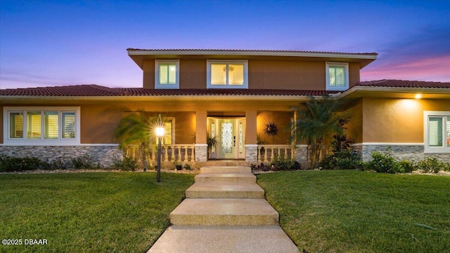 view of front of home featuring covered porch and a lawn