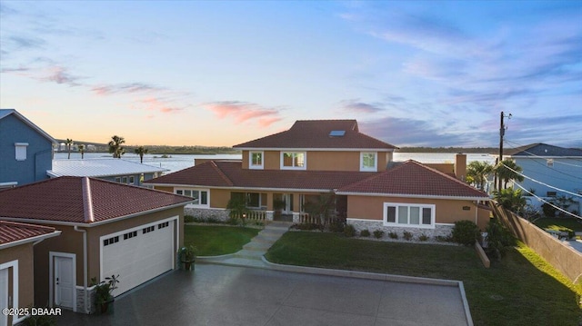 view of front of house featuring a garage and a yard