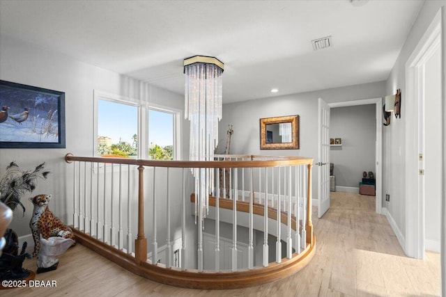 hallway featuring a chandelier and light hardwood / wood-style flooring