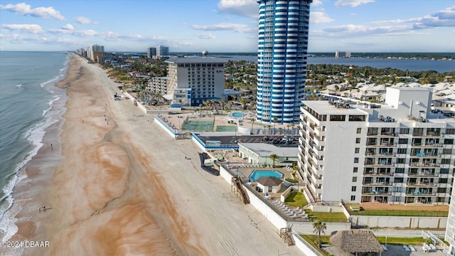 birds eye view of property with a water view and a beach view