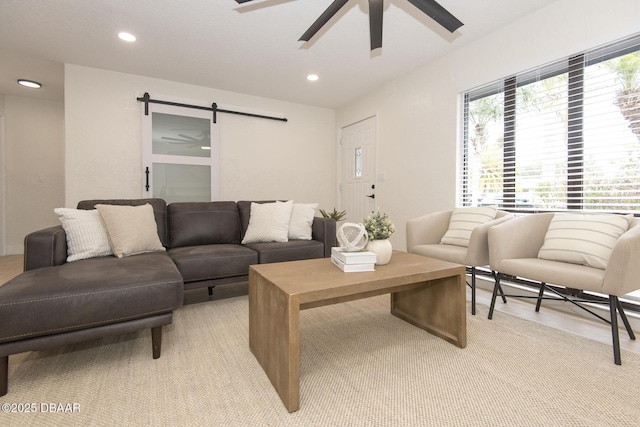 living room featuring a barn door and ceiling fan