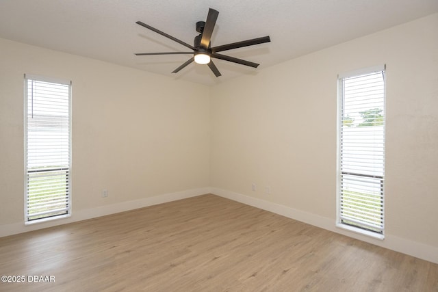 unfurnished room featuring a wealth of natural light, light hardwood / wood-style floors, and ceiling fan